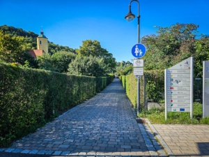 Weg führt weiter und zwischen Hecken hindurch