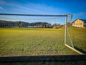 Am Sportgelände mit Sportheim vorbei