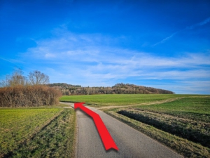 Geteerter Feldweg in Freifläche mit großer Linkskurve