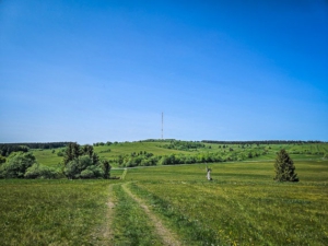 Weg über eine Höhenkuppe mit Sendemast im Blick