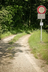 An Schild vorbei in den Wald