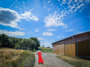 Außerhalb von Haimendorf unterhalb des Moritzberg wandern Sie an der landwirtschaftlichen Halle vorbei