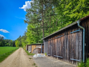 An Scheune (mit Wegweisern) vorbei